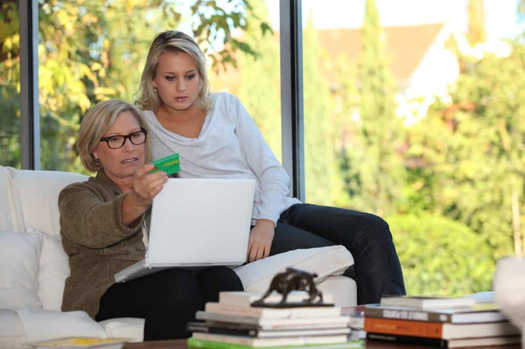 Mother and daughter reviewing insurance options on laptop.